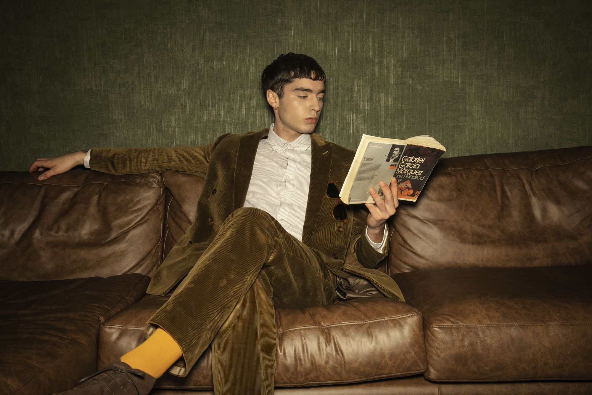 Relaxed man wearing a tailored suit reading a book